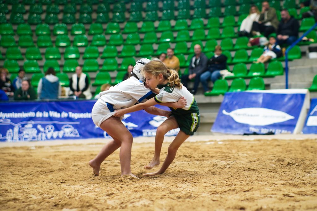 Dos niñas compiten en lucha canaria.